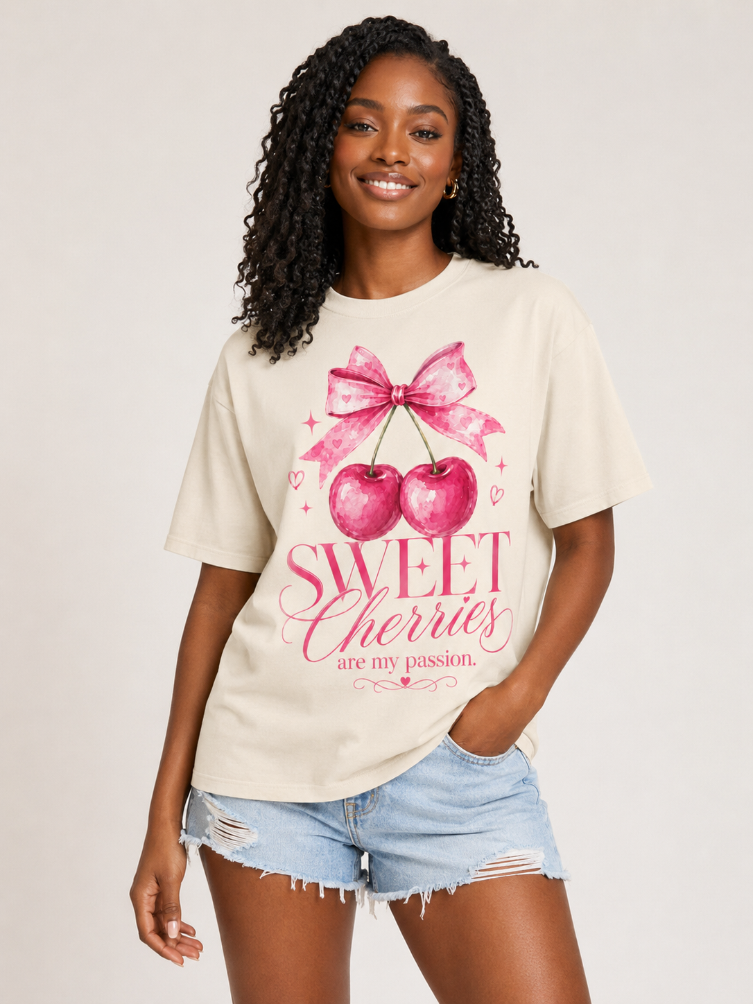Woman wearing a beige t-shirt with pink cherry graphic and text 'Sweet Cherries are my passion'